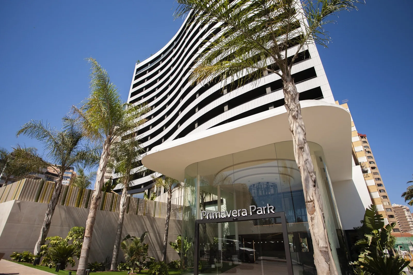 Entrada del Hotel Primavera Park entre palmeras, en el centro de Benidorm