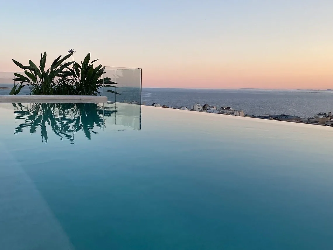 Piscina infinita del Selvático Rooftop del Hotel Primavera Park al atardecer, con el mar al fondo